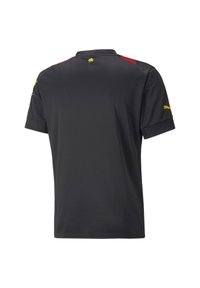 Jersey deportivo de mangas cortas negro con el logo amarillo de Puma en la manga derecha y un pequeño emblema amarillo cerca del cuello, detalles rojos en los hombros.