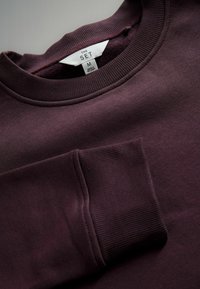 Bordowy sweatshirt z prążkowanym kołnierzem i mankietami, z przednią kieszenią oraz metką oznaczoną "THE SET" w rozmiarze M. Miękka tekstura.