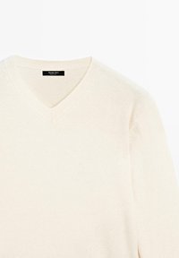 Kremfarvet V-hals sweater med ribbet krave og lange ærmer, lavet af blødt strikket stof fra Massimo Dutti.