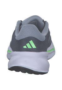 Sneaker da corsa grigia e verde vista da dietro, con tomaia in mesh, colletto imbottito e suola bianca testurizzata.