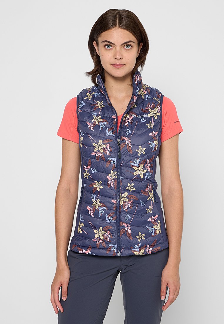 Chaleco acolchado azul marino con estampados florales en amarillo, azul y marrón. Tiene un cierre frontal, un cuello alzado y un diseño ajustado.