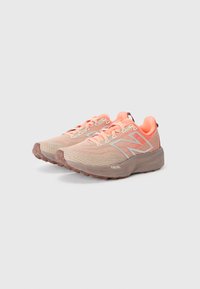 Lightweight, tan and coral running shoes with a textured knit upper, robust sole, and “FUELCELL” branding on the side.