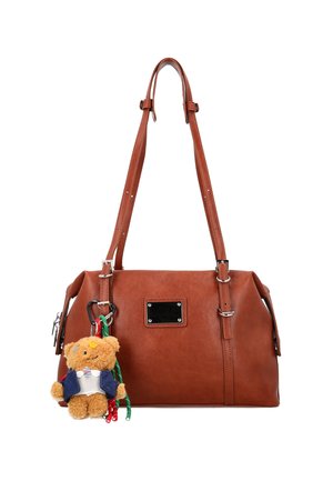 Bruine leren handtas met verstelbare schouderbanden en een kleine teddybeer sleutelhanger met een blauwe jas en wit overhemd, bevestigd aan de voorkant.