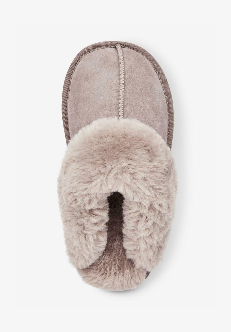 Pantofole in suede grigio chiaro con fodera in pelliccia morbida. Presentano una parte superiore testurizzata, dettagli cuciti e un design aperto sulla punta.