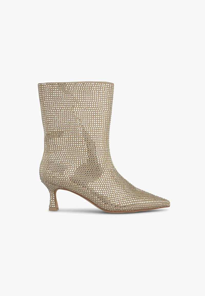 Beżowe botki za kostkę z wyostrzonym noskiem, wykonane z perforowanego materiału, posiadające smukły obcas i minimalistyczny design.