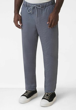 Könnyű, szürke mintás nadrág, gumis derékpánttal és húzózsinórral. Oldalzsebekkel, egyenes szabású, fekete tornacipővel párosítva.