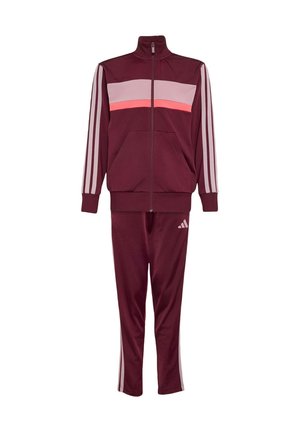 Survêtement marron avec veste zippée, rayures horizontales roses et corail sur la poitrine, manches rayées et pantalon assorti avec logo sur la jambe gauche.