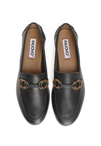 Zwarte leren instappers met een ronde neus, voorzien van twee goudkleurige ronde accenten en een gevoerde binnenzool. Textuur oppervlak, minimalistisch ontwerp.