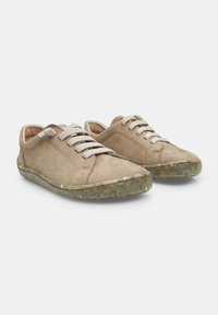 Tenisi bej din suede cu șireți gri, vârf rotund și talpă din cauciuc texturată de culoare verzui, având detalii subtile de cusătură pe părțile laterale.