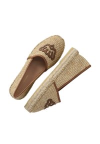 Alpargatas de yute trenzado con acentos de cuero marrón y un logo elevado. Presentan un tejido plano y un tacón cuña cubierto de yute.