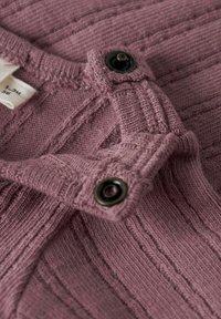 Sweter pleciony, prążkowany w kolorze mauve z teksturowanym wykończeniem. Wyposażony w czarne zapięcia na guziki na ramieniu, umożliwiające regulację dopasowania.
