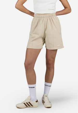 Shorts beige, lunghi fino al ginocchio, realizzati in tessuto morbido con vita elastica e tasche laterali. Presentano un piccolo logo bianco sull'orlo.