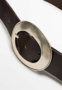 Cintura in pelle marrone con una grande fibbia metallica ovale. Il materiale è liscio e presenta diversi fori per la regolazione.