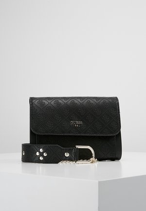 Schwarze Guess Crossbody-Tasche mit geprägtem Logomuster, silberner Kettenriemen und Metallschnalle, auf weißer Oberfläche mit einfachem Hintergrund platziert.