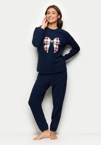 Marineblå to-delt sæt bestående af en langermet top med et ternet sløjfedesign og matchende bukser, lavet af blødt og behageligt stof.