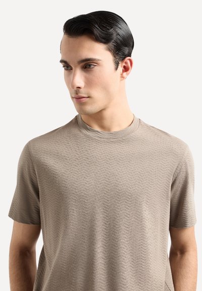 T-shirt beige a maniche corte con scollatura rotonda e motivo a zigzag, realizzato in un tessuto morbido e leggero.