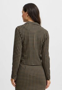 Braune und schwarze Blazer im Hahnentrittmuster mit taillierter Passform, langen Ärmeln und Reverskragen, ausgestattet mit einer glatten Stoffstruktur.