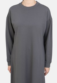 Graues Sweatshirtkleid aus weichem Stoff, mit rundem Ausschnitt, langen Ärmeln und seitlichen Nähten für eine lockere Passform.