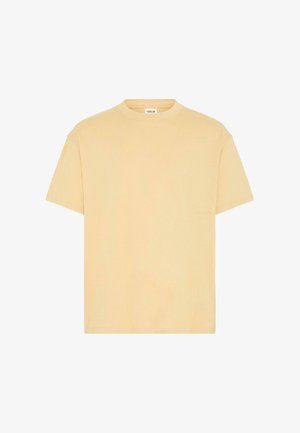 Lühikeste varrukatega, ümmarguse kaelusega T-särk pehmest, kergest puuvillast, millel on heledat kollast värvi ja minimaliistlik disain koos delikaatse kaubamärgisildiga.