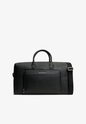 Μαύρη δερμάτινη τσάντα duffel με διπλές λαβές, μπροστινή τσέπη με φερμουάρ, ρυθμιζόμενο ιμάντα ώμου και μικρό λογότυπο Tommy Hilfiger στην μπροστινή τσέπη.