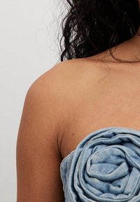 Top in denim a tubo con un design arricciato simile a un fiore in tessuto blu chiaro, con una texture liscia e stile senza spalline.