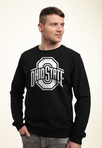 Sweatshirt noir avec un grand logo abrégé de l'Ohio State en blanc. Encolure ronde et poignets côtelés, avec une coupe décontractée.