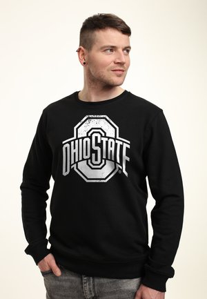 Felpa nera con grande logo Ohio State in bianco, effetto usurato. Girocollo e polsini a coste, con una vestibilità rilassata.