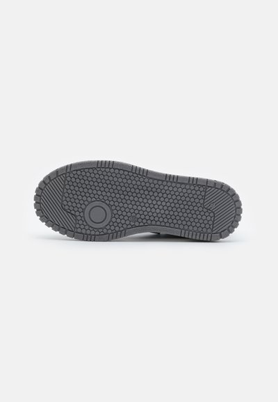 Sole di scarpa grigia con una superficie texturizzata caratterizzata da motivi circolari e esagonali; materiale in gomma resistente; forma piatta con bordi scanalati.