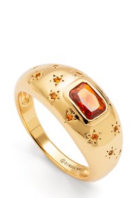 Anillo de tono dorado con una piedra rectangular roja, acentuado con pequeñas piedras preciosas naranjas y patrones en forma de estrella en la banda.