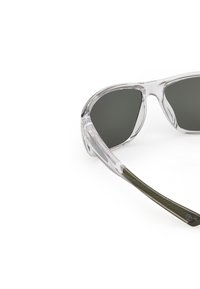 Ochelari de soare cu ramă transparentă și lentile gri închis, având un design elegant și temple verzi cu textură. Fără branding sau modele vizibile.