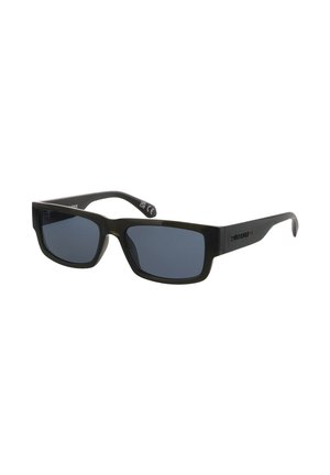 Schwarze rechteckige Sonnenbrille mit dunklen Gläsern und dicken Bügeln, leicht seitlich geneigt vor weißem Hintergrund.