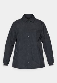 Jachetă cu carouri negre, cu mâneci lungi, închidere cu buton și un buzunar pe piept. Confecționată dintr-un material ușor, texturat. Include manșete elastice.