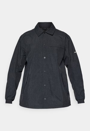 Chaqueta de cuadros negros con mangas largas, cierre de botones y un bolsillo en el pecho. Fabricada con tejido ligero y texturizado. Incluye puños elásticos.