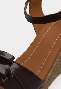 Καφέ πλατφόρμα σανδάλι με λουριά από δέρμα, ραμμένη ταμπά εσωτερική σόλα και πλεκτή σόλα από τζούτ.