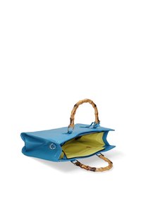 Borsa azzurra con texture e manici in stile bambù, aperta per rivelare un luminoso interno giallo. Presenta una chiusura superiore con zip e dettagli in metallo.