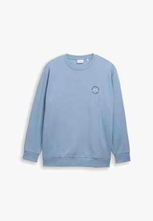Helles blaues Langarm-Sweatshirt mit Rundhalsausschnitt und kleinem schwarzem, runden Logo auf der linken Brust, das "Tom Tailor 1962" zeigt.
