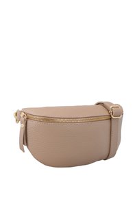 Borsa a tracolla in pelle beige con forma curva, zip dorata e tracolla regolabile. Presenta una superficie texturizzata e un piccolo pon-pon laterale.