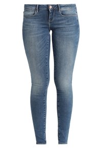 Úzké džíny ve světle modrém denimu, s středně vysokým pasem, pěti kapsami a jemnými efekty vyblednutí na nohavicích.