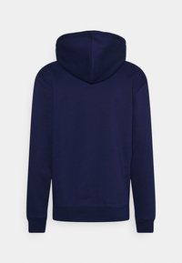 Marinblå hoodie med mjuk textur, med en centrerad huva, långa ärmar och ribbade manschetter och nederkant. Inga synliga logotyper eller mönster.