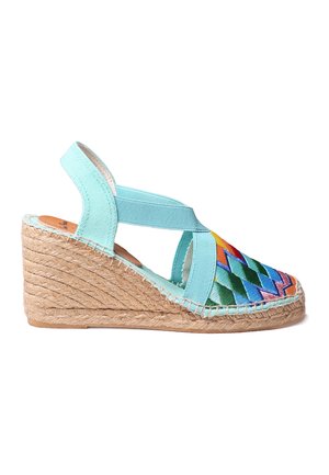 Wedge espadrille dengan kain hijau mint dan pola zigzag bordir berwarna-warni. Sol tali jute. Desain slingback dengan tali silang.