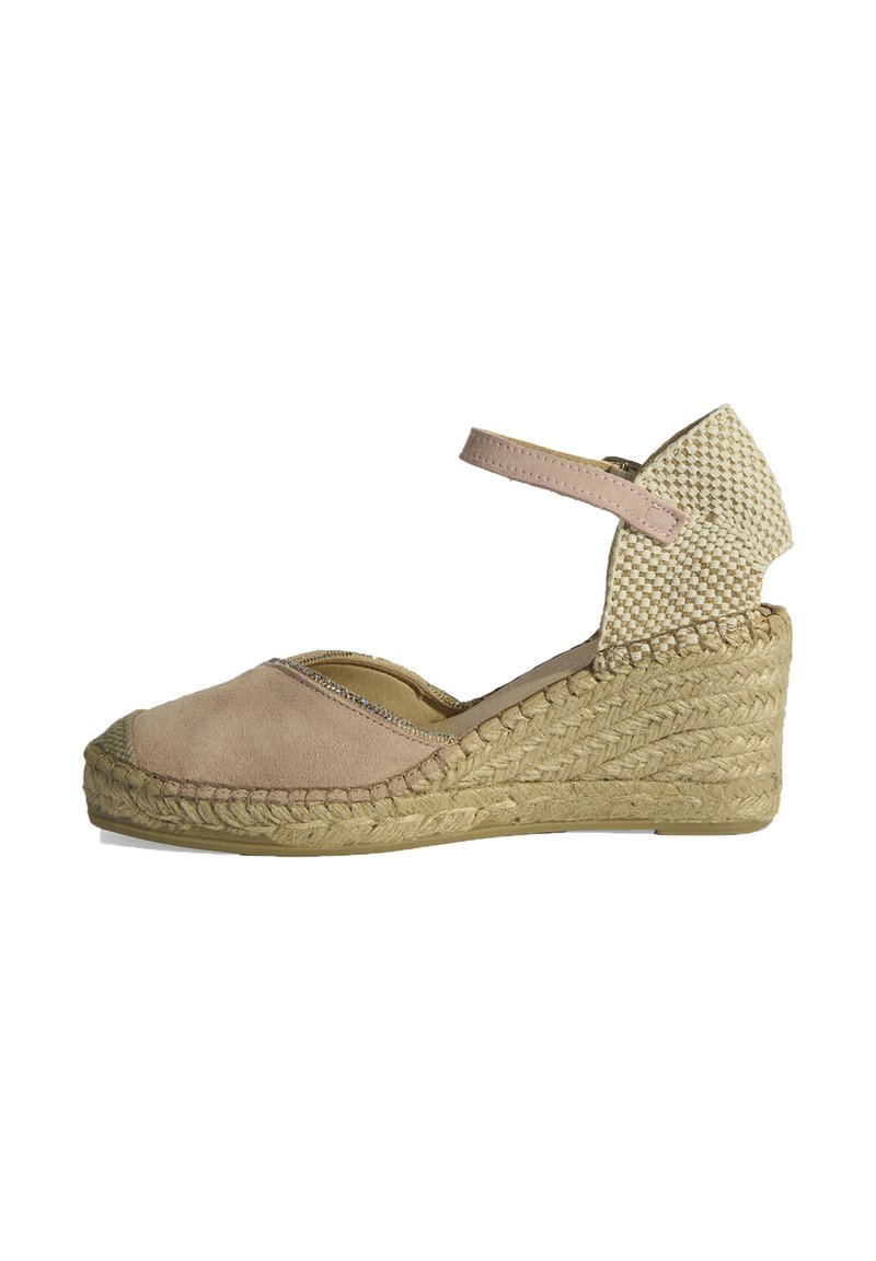 Escarpin compensé en suede beige, avec un talon en paille tissée, une bride à la cheville, et un design à bout rond avec une couture décorative.