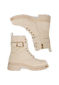 Beżowe botki za kostkę z ekoskóry o teksturowanym wykończeniu, z akcentami w kolorze złotym, sznurowanym przodem, zamkiem błyskawicznym z boku i solidną podeszwą typu lug.