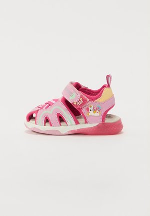 Pink sandals with a closed toe design, featuring adjustable straps, a textured sole, and a colorful unicorn graphic on the side.