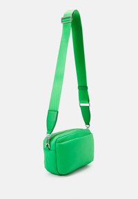 Borsa a tracolla verde con forma rettangolare, texture imbottita, materiale liscio, tracolla regolabile e dettagli in metallo argentato.