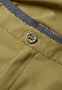 Khakifarbene Stoffhosen mit einem grauen elastischen Bund, genähten Nähten und einem runden Metallknopf, auf dem "ENDURA" eingeprägt ist.