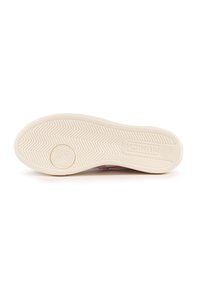 Soletta della sneaker in gomma crema con un motivo a spina di pesce. Presenta un logo del marchio impresso e un design floreale circolare al centro.