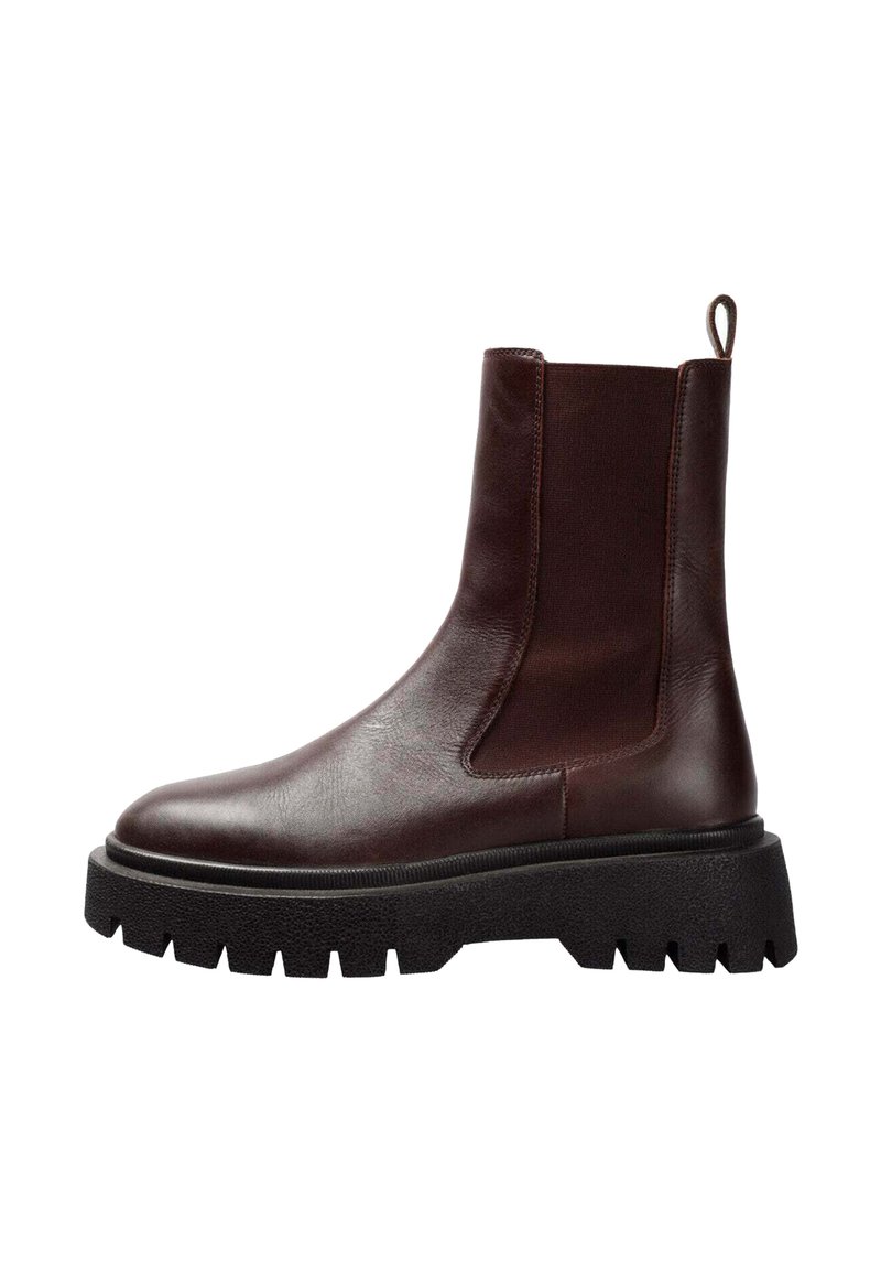 Botas Chelsea de cuero marrón con paneles elásticos laterales, puntera redonda y suela gruesa y chunky negra con surcos profundos para mayor tracción.