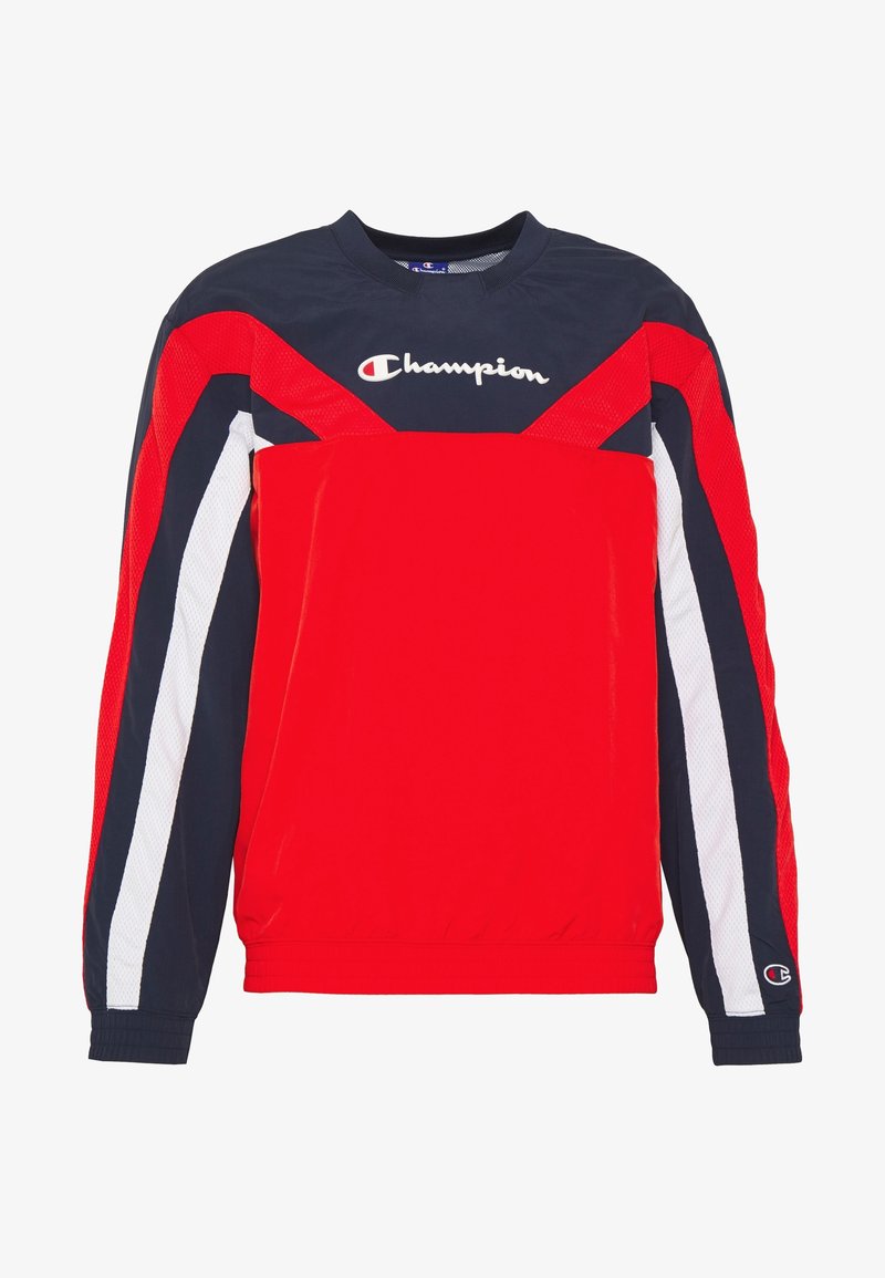 Sweat-shirt Champion manches longues rouge, marine et blanc avec logo sur la poitrine et un petit logo sur le bord de la manche gauche.