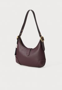 Borsa a spalla in pelle bordeaux scuro con una sola tracolla regolabile, fibbia dorata e chiusura a zip superiore con dettaglio a linguetta frontale.