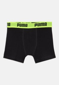 Fekete boxer alsónadrág neon zöld derékkal, melyen fekete "PUMA" felirat található; puha anyagból készült, sima textúrával és varrott részletekkel.